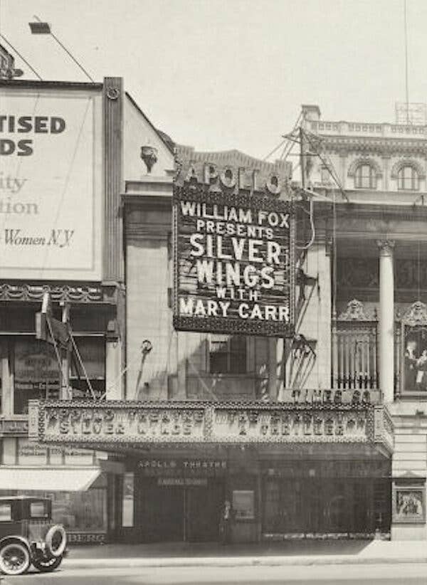 Apollo Theatre marquee with William Fox Presents Silver Wings with Mary Carr spelled out in lighted capital letters, a 1920s era car parked out front