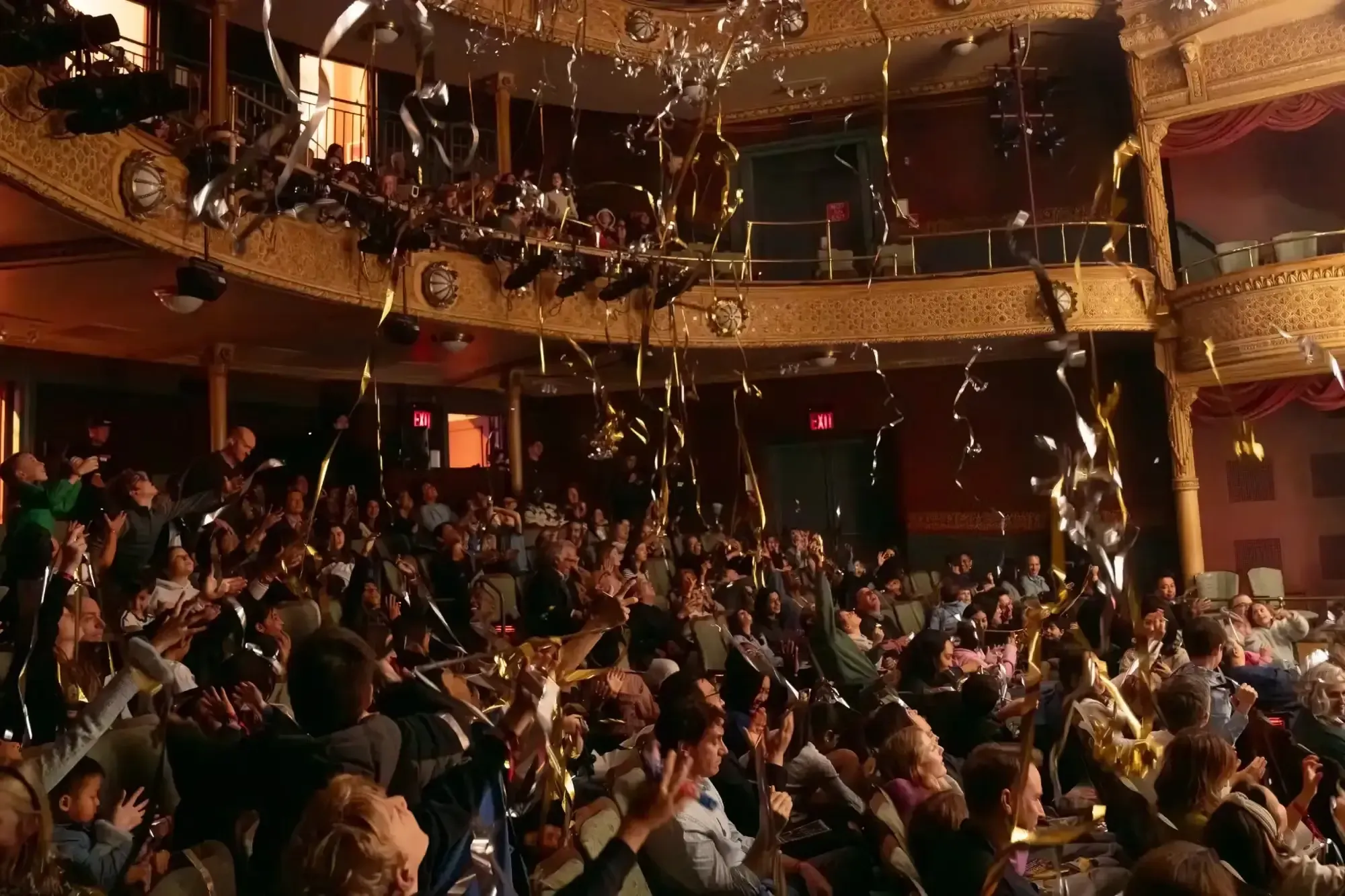 Confetti streamers fall on the audience in the New Victory theater.